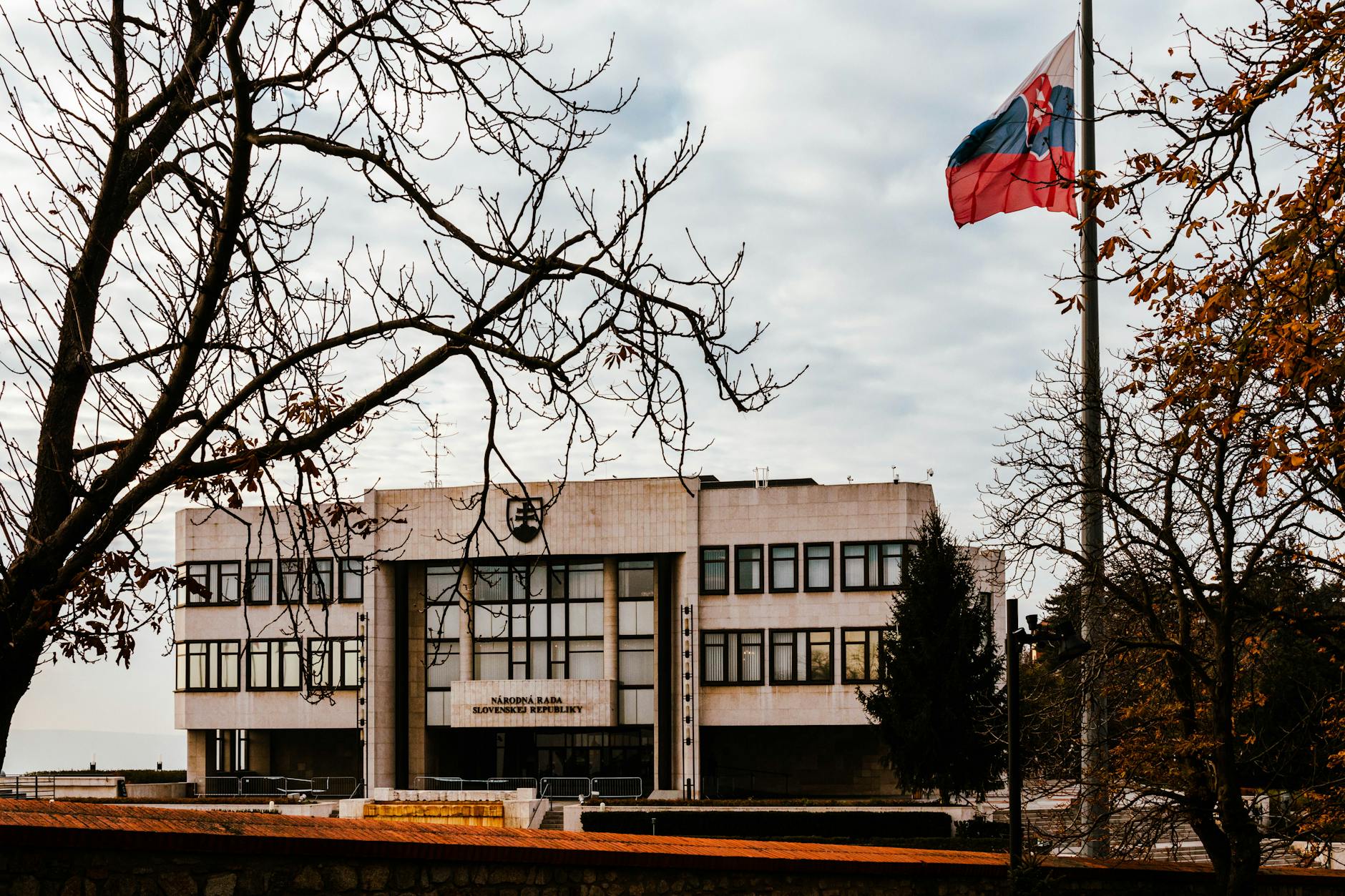 Slovak flag fluttering beside a government building in Slovakia, epitomizing the importance of Slovak to English translation in bridging linguistic gaps.