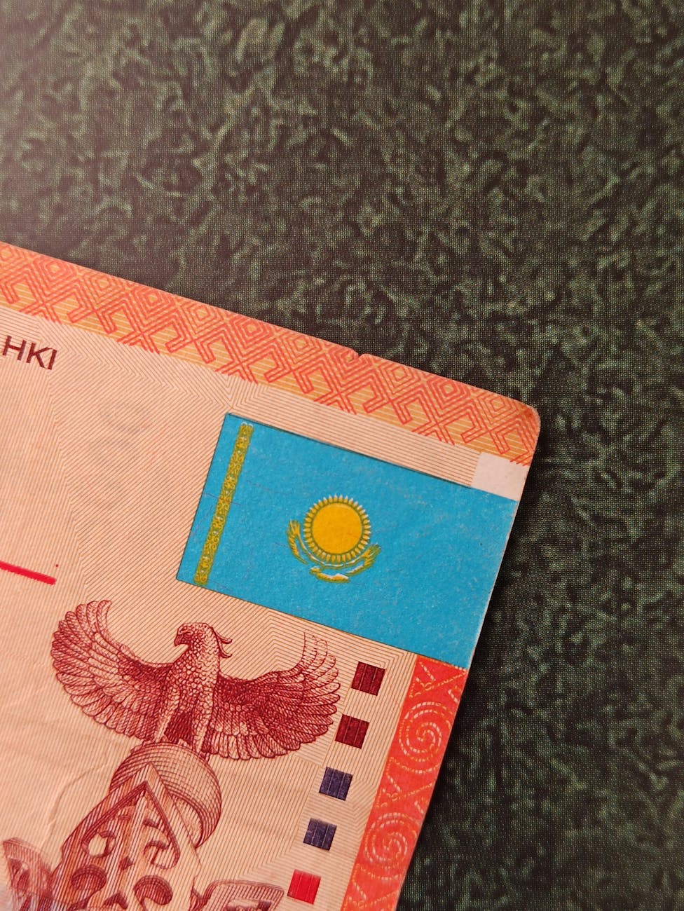 Close-up of a Kazakhstani banknote with the national flag, embodying the country's economic landscape and the significance of English-Kazakh translation in global commerce.