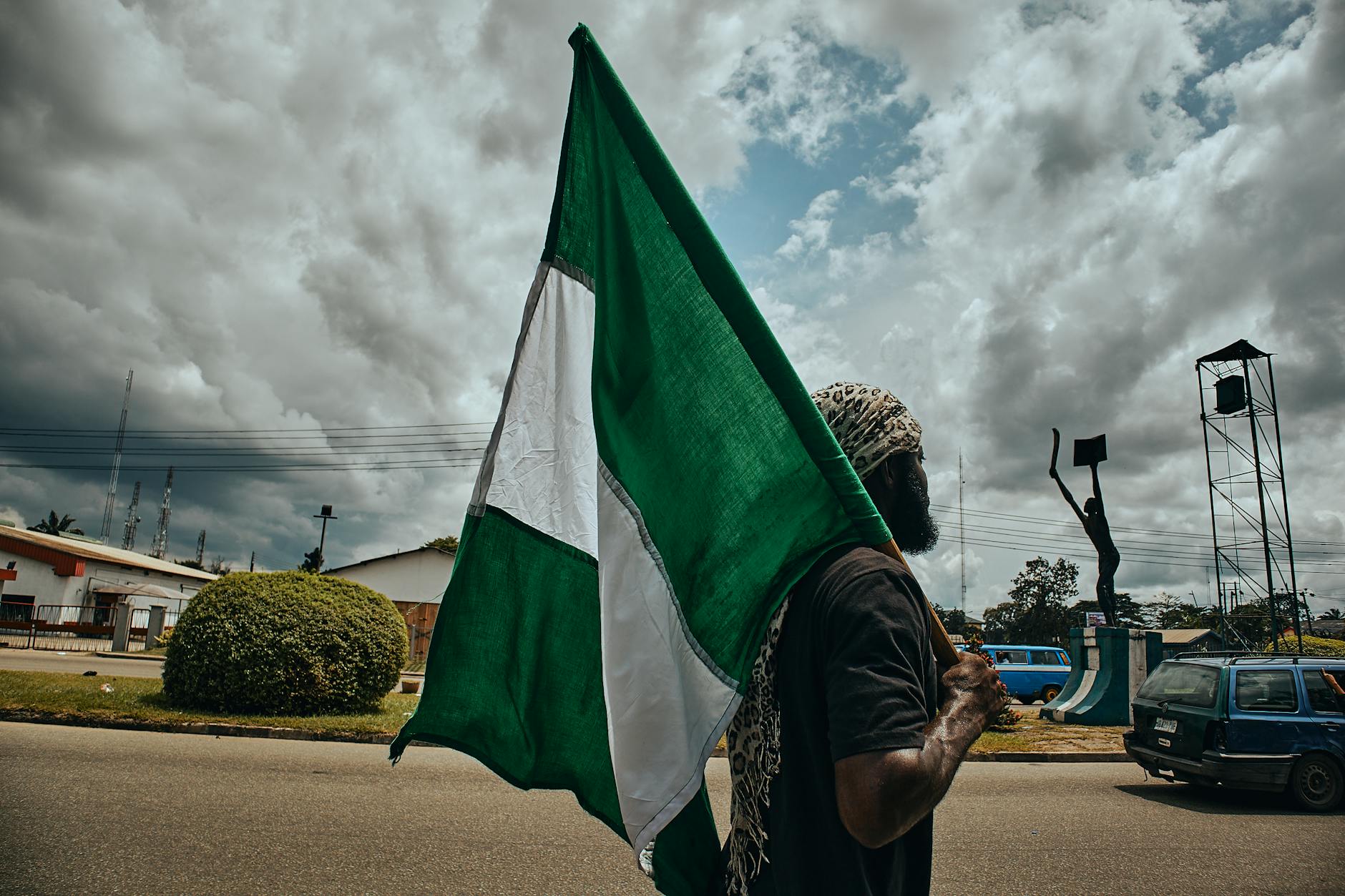 A person proudly holding up the Nigerian flag, symbolizing the country's cultural diversity and the importance of Hausa language translation in English-speaking regions.