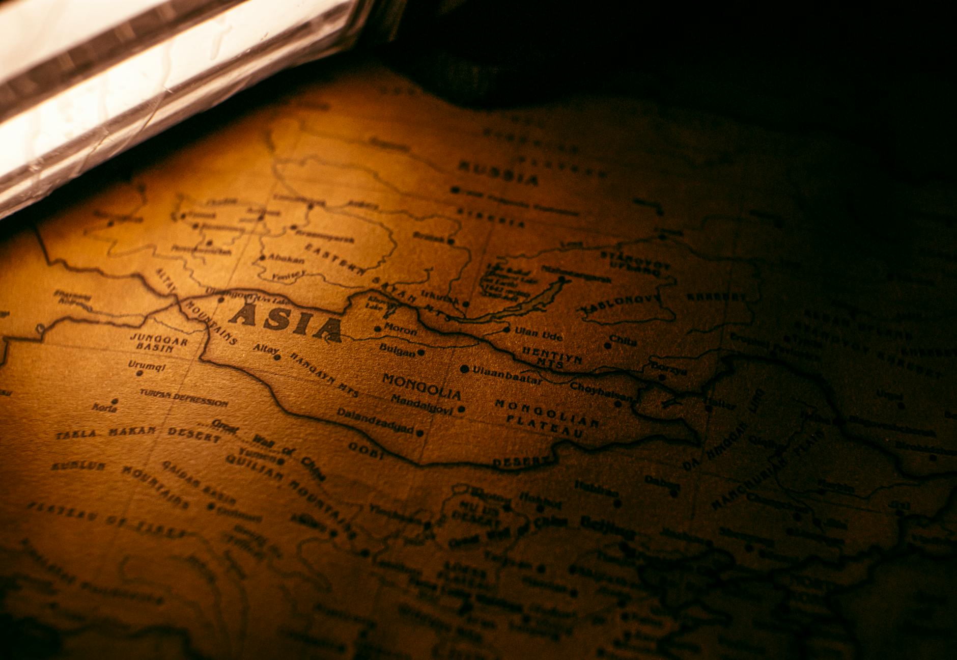 A Syriac translator working on a laptop, surrounded by ancient manuscripts, symbolizing the bridge between historical legacy and modern technology.