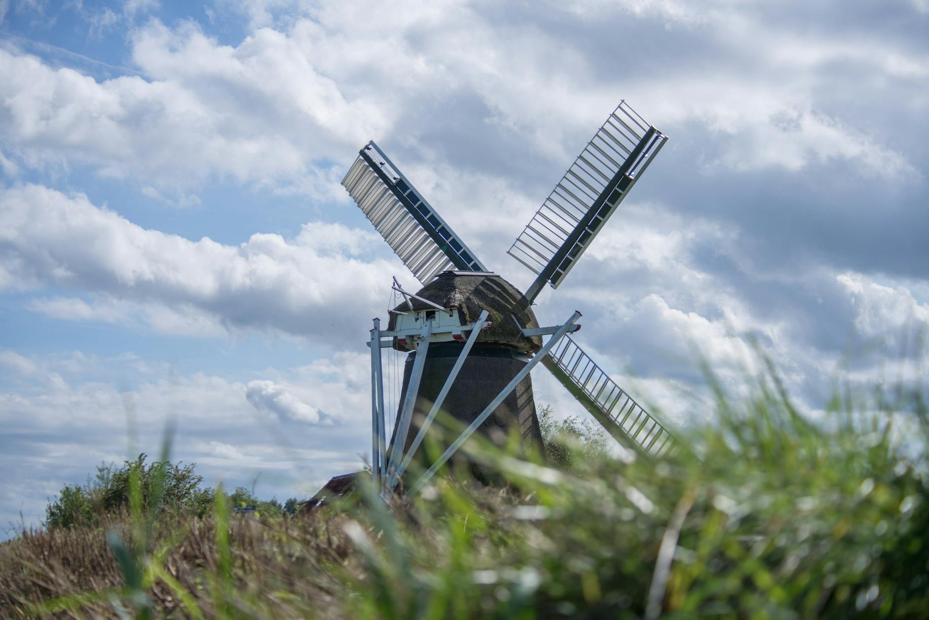A traditional Dutch windmill set against a dynamic sky, embodying the historical connection between the Netherlands and the Afrikaans language.