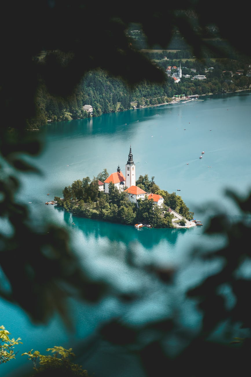 A picturesque view of an island church in Lake Bled, Slovenia, showcasing the country's stunning landscapes accessible through Slovenian to English translation services.