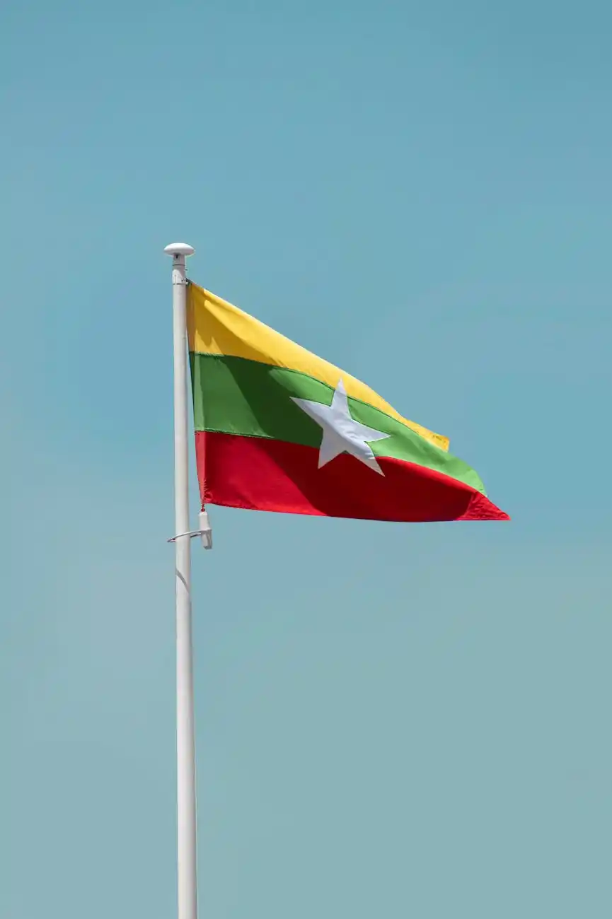 Myanmar flag hanging on a pole against clear blue sky background