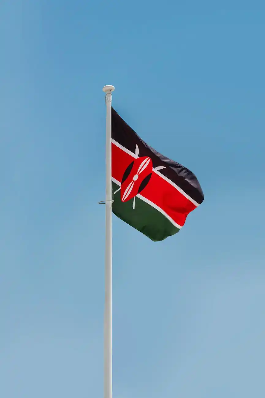 Kenyan flag waving against a blue sky background.