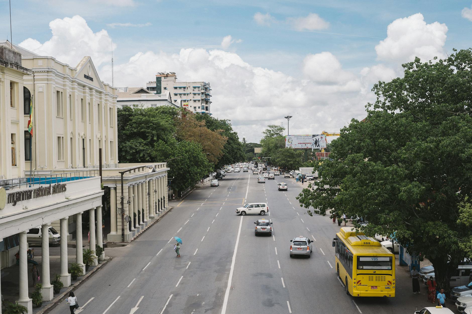 Street view in Myanmar with bustling traffic and colonial architecture, highlighting the cultural backdrop where the Zyphe Chin language is spoken.